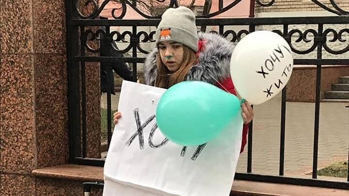 Фото дня: девочка с плакатом "Хочу жить!" напротив Минздрава