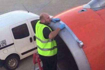 Заклеивающий скотчем повреждение на самолете мужчина попал на камеру
