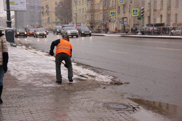 В Петербурге снег между припаркованными машинами убирают дворники
