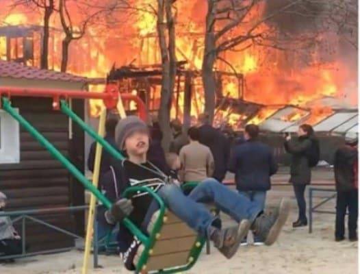 Мальчик на качелях рядом с пожаром стал символом невозмутимости на фоне проблем