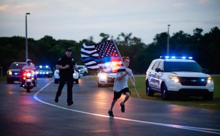 Мальчик из Флориды с синим американским флагом в руках пробегает по миле в честь каждого погибшего офицера США