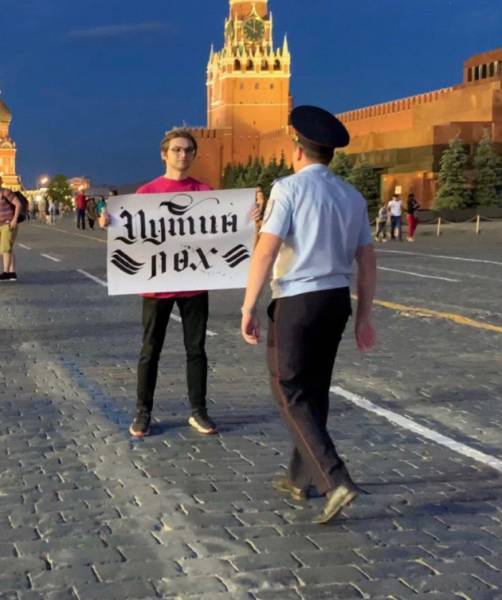 Российский активист вышел на Красную площадь с плакатом “Путин – лох”