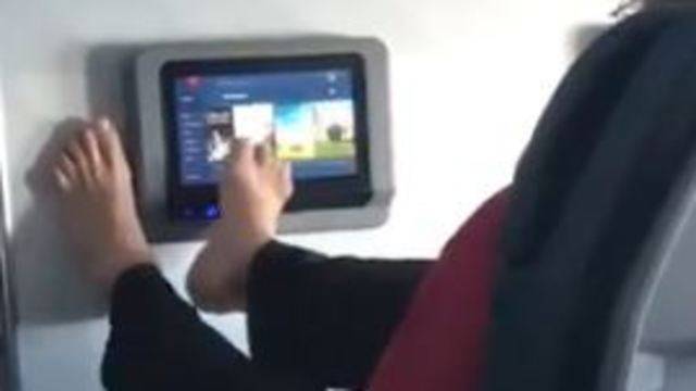 Скандальное видео: пассажир самолета выбирает фильм босой ногой