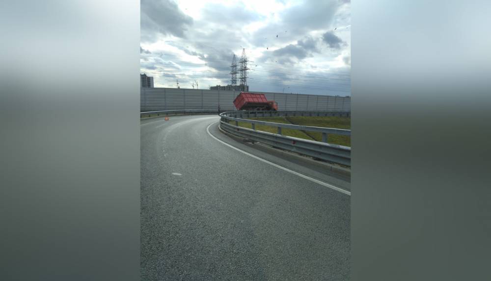 При съезде на Красносельское шоссе на КАД опрокинувшийся кузов КАМаза перегородил дорогу