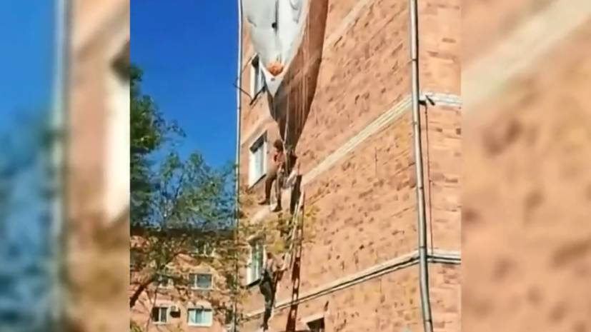 В Приморье десантник зацепился парашютом за крышу дома и повис на высоте третьего этажа — видео
