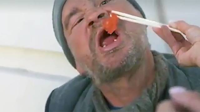 Бездомному из ролика с близняшками, кормящими его роллами, несут еду