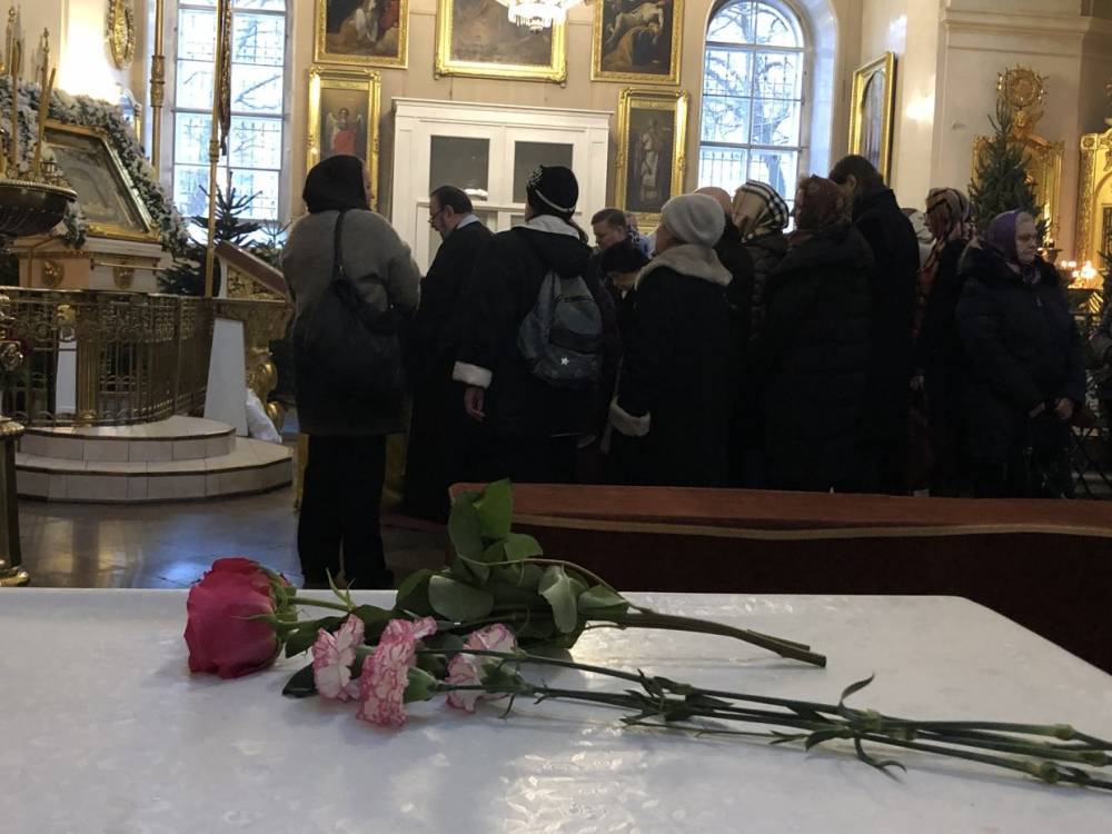 Люди несут цветы в Спасо-Преображенский собор на отпевание онколога Андрея Павленко