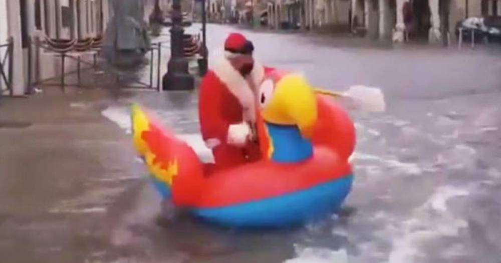 Санта-Клаус проплыл по затопленным улицам Венеции на надувном попугае