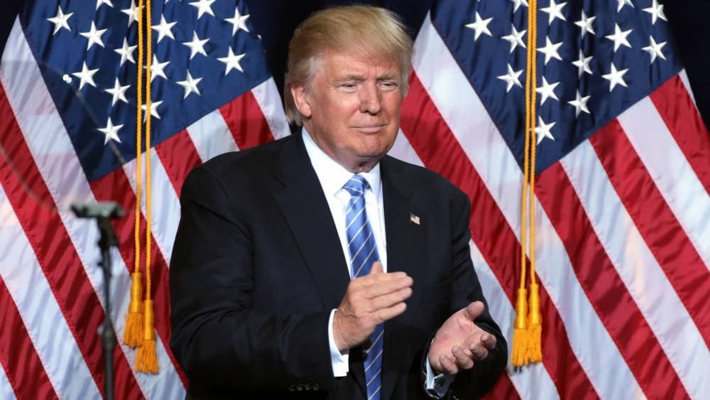 Трамп вновь обнял и расцеловал флаг США