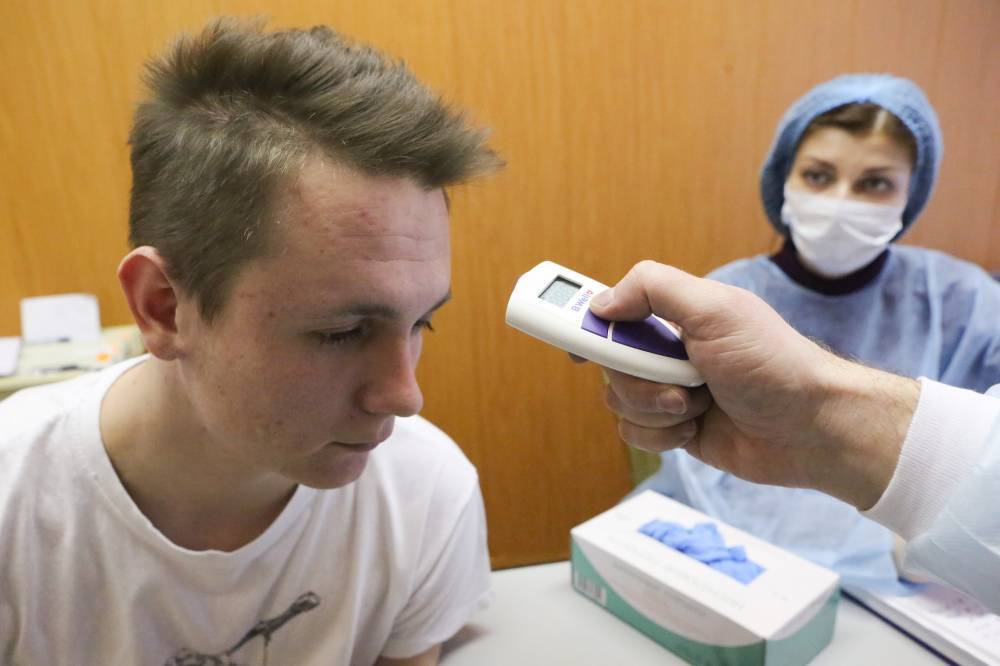 Москвичам измеряют температуру и выдают маски при входе в поликлиники