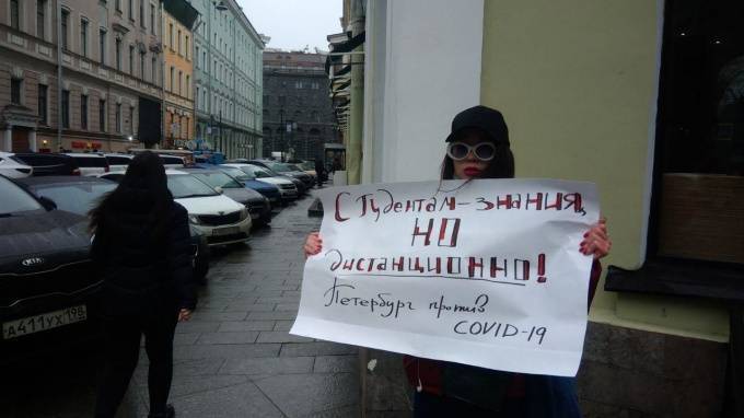 В центре Петербурга девушка с плакатом требует перевести студентов на дистанционное обучение