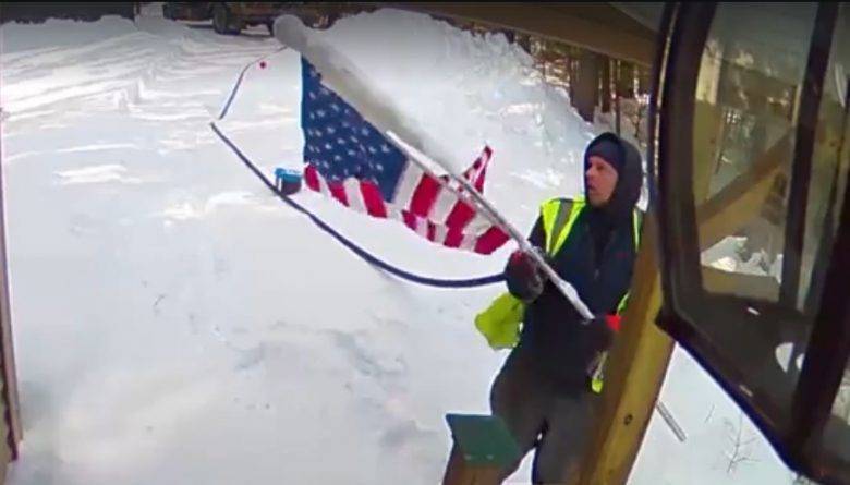 Курьер поднял упавший американский флаг у дома ветерана в день Битвы при Иодзиме, несмотря на снегопад