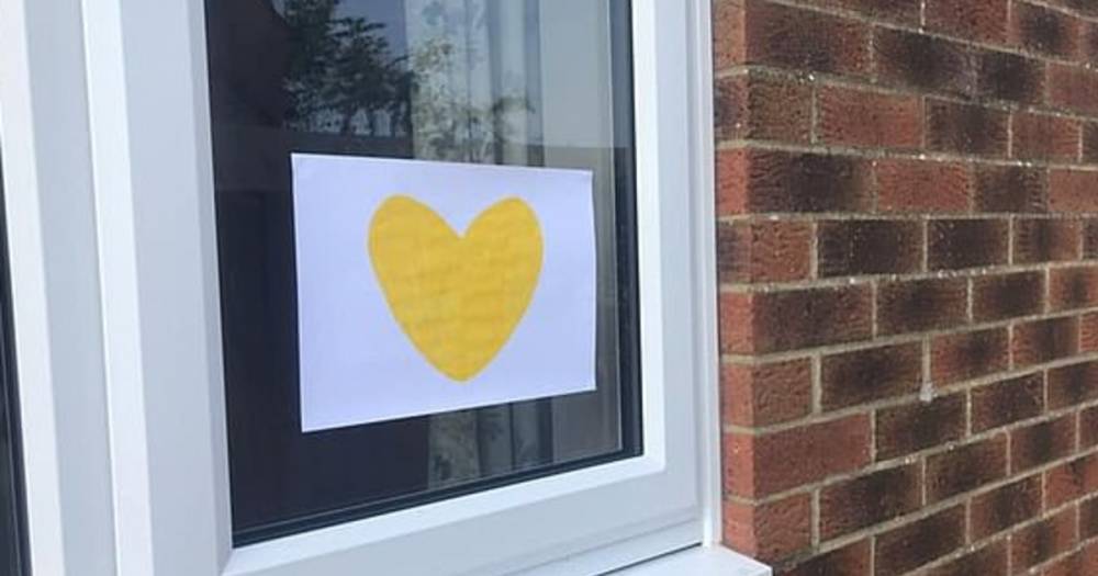 Потерявшие родных из-за COVID семьи приклеивают на окна желтые сердца
