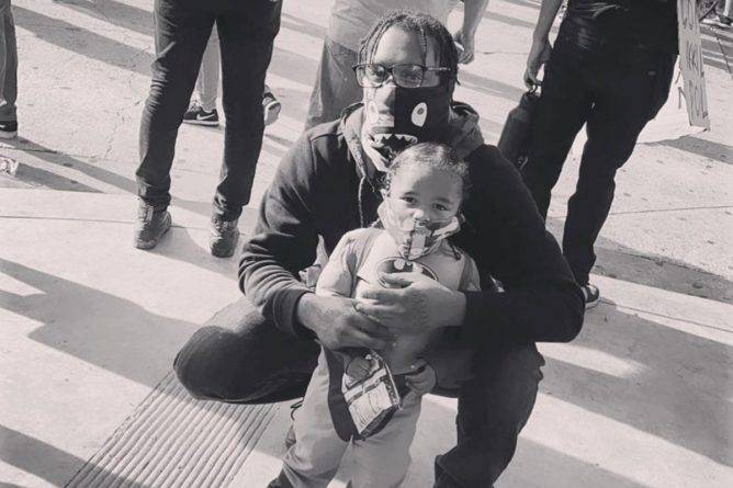 Мирный протестующий требует наказать полицейского, который навел пистолет на его сына