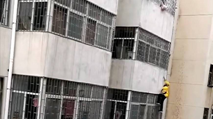 Курьер в Китае забрался без страховки на третий этаж, чтобы спасти девочку (Видео)