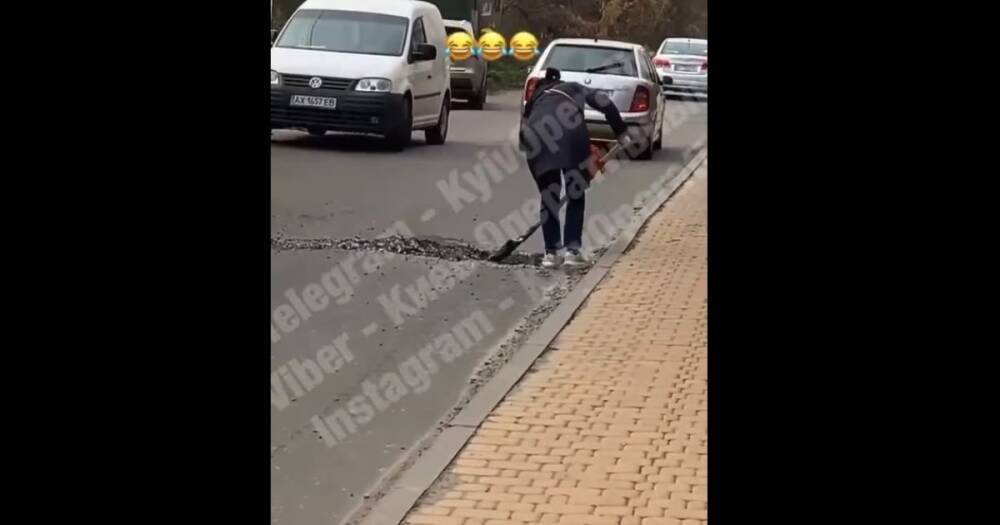 "Выехать нельзя". В Киеве женщина разрыла яму на дороге, засыпанную водителем (видео)