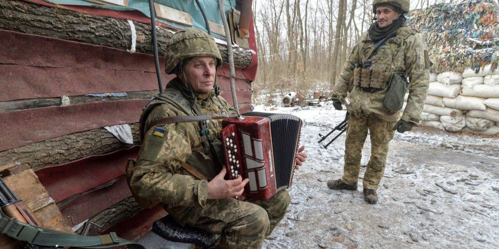 Громкая тишина. Украинский военный играет на баяне возле линии разграничения на Донбассе — фото дня