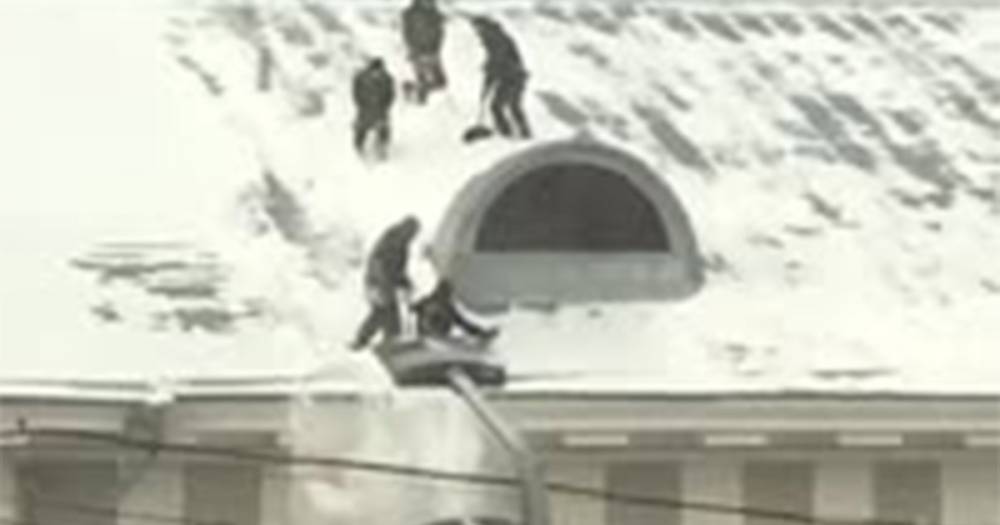 Скатывающиеся с крыши во время уборки снега дворники в Москве попали на видео