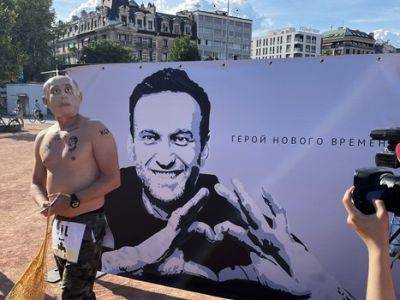 В Женеве некто в маске Путина "выплачивал на коррупцию" у портрета Навального