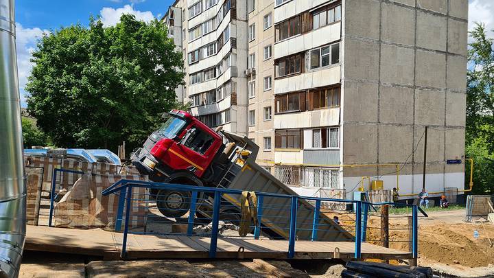 Самосвал с песком съехал в котлован во дворе дома в Москве