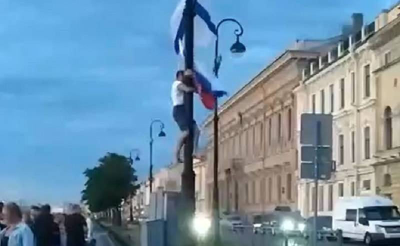 Видео: босой петербуржец украл со столба флаги России и ВМФ