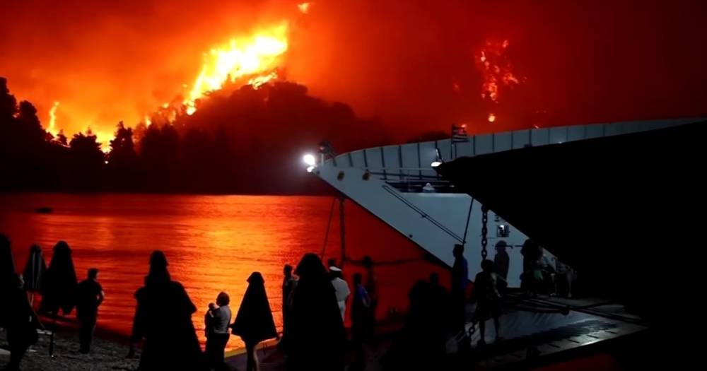 Спасенные на пароме и лодках греки наблюдали, как огонь поглощает их остров (видео)