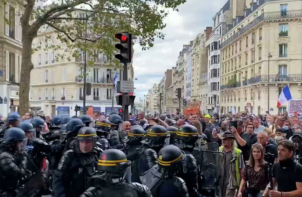 Бутылки, петарды, слезоточивый газ: в Париже проходит очередная акция против антиковидных ограничений (видео)
