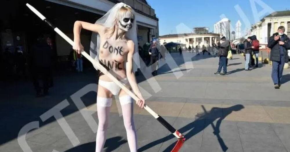 Представительница Femen устроила акцию с косой возле ж/д вокзала в Киеве (ФОТО 18+)