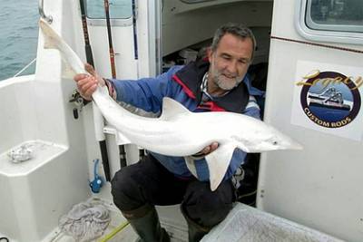 Рыбак взял на руки редчайшую акулу белого окраса