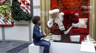 В США Санта-Клаусов закрыли защитным стеклом и запретили детям сидеть у них на коленях