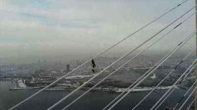 Альпинист на 300-метровой высоте снял клип о своей работе по очистке Русского моста ото льда (1 фото + 1 видео)