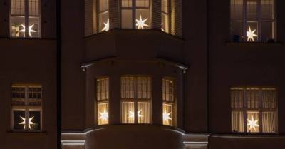 130 новогодних звёзд зажглись в окнах исторического здания в центре Риги