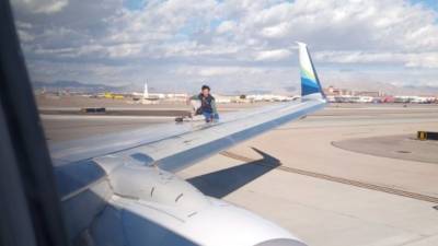 Мужчина забрался на крыло самолета, готовившегося к вылету из аэропорта. Видео
