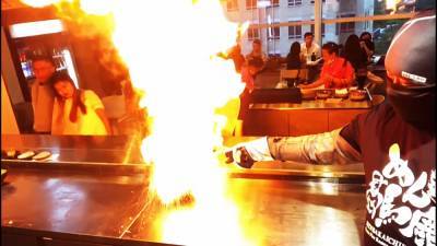 Повара подают «огненные» блюда в ресторане Сингапура.