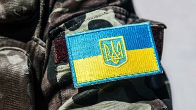 Вооруженный мужчина в форме НАТО с флагом Украины устроил...