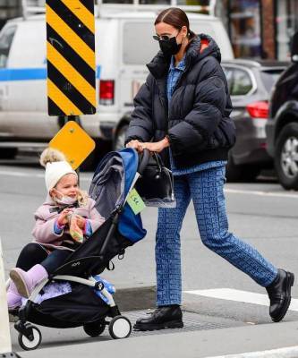 Зимний образ для мам (и не только): Ирина Шейк в пуховике и костюме из денима на прогулке с дочерью