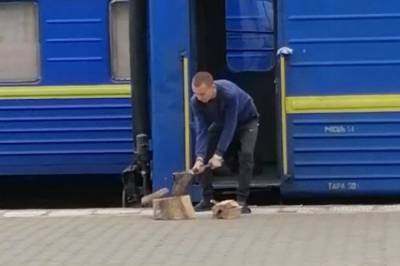 Проводник "Укрзализныци" рубит дрова на перроне для обогрева вагонов. Видео