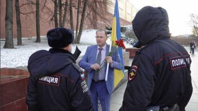 Россиянин с флагом Украины вышел на пикет против Путина под Кремлем: полиция почти сразу пришла задерживать