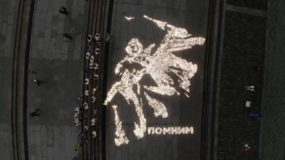 На Поклонной горе воссоздали плакат «Отстоим Москву!» из 10 тысяч зажжённых свечей — видео с беспилотника