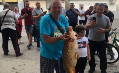 Мужчина в подтопленных Черновцах поймал руками огромного карпа в луже, видео: "не менее 10 кг"
