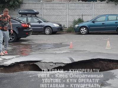 В Киеве возле нового ЖК проваливается асфальт: в огромной яме бурлит вода