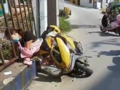 В Китае женщина упала со скутера и застряла головой в заборе