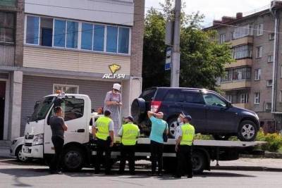 Новосибирская пенсионерка залезла на эвакуатор и не давала увезти ее машину