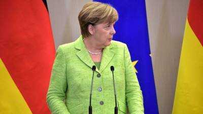 Обвиненная в лицемерии Меркель впервые появилась на публике в маске