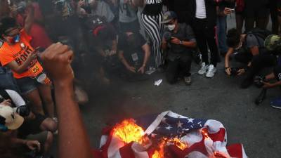 На расовом протесте в США коммунисты устроили провокацию с сожжением флага: видео
