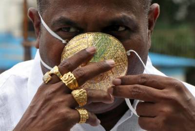 Индиец носит золотую маску против Covid-19