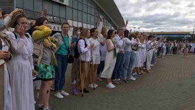 Девушки выстроились в живую цепь с цветами в руках в Минске
