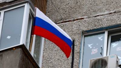 На мужчину, выбросившего российский флаг в урну, заведено уголовное дело