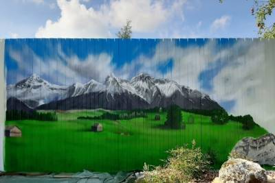 Тверская художница украсила забор горным пейзажем