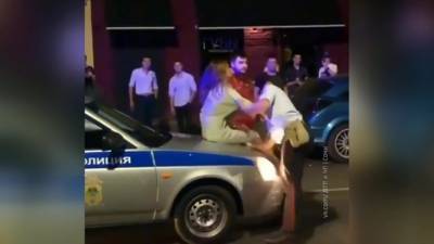 В Краснодаре девушка взобралась на крышу полицейского автомобиля